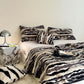 Stacked plush faux fur throw blankets in pink and zebra print colorways