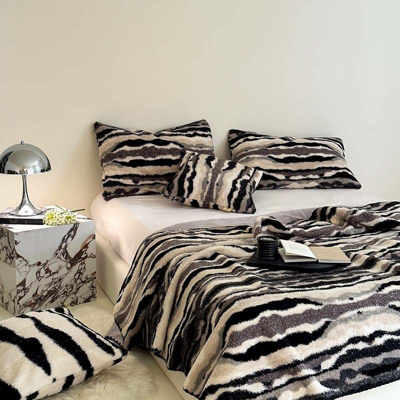 Stacked plush faux fur throw blankets in pink and zebra print colorways