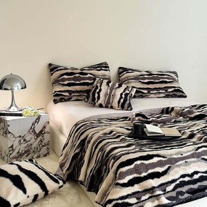 Stacked plush faux fur throw blankets in pink and zebra print colorways
