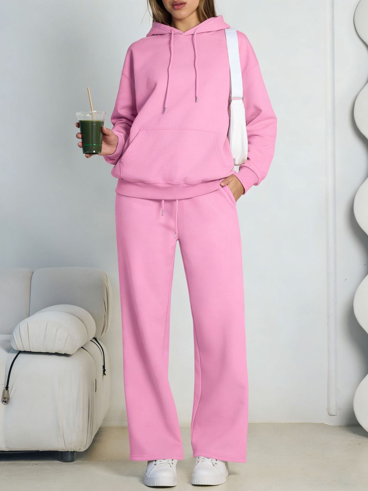 Pink fleece hooded sweatshirt and wide-leg sweatpants set worn by a model