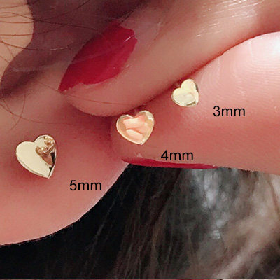 Mini heart gold stud earring on a clean studio background showing the gold tone