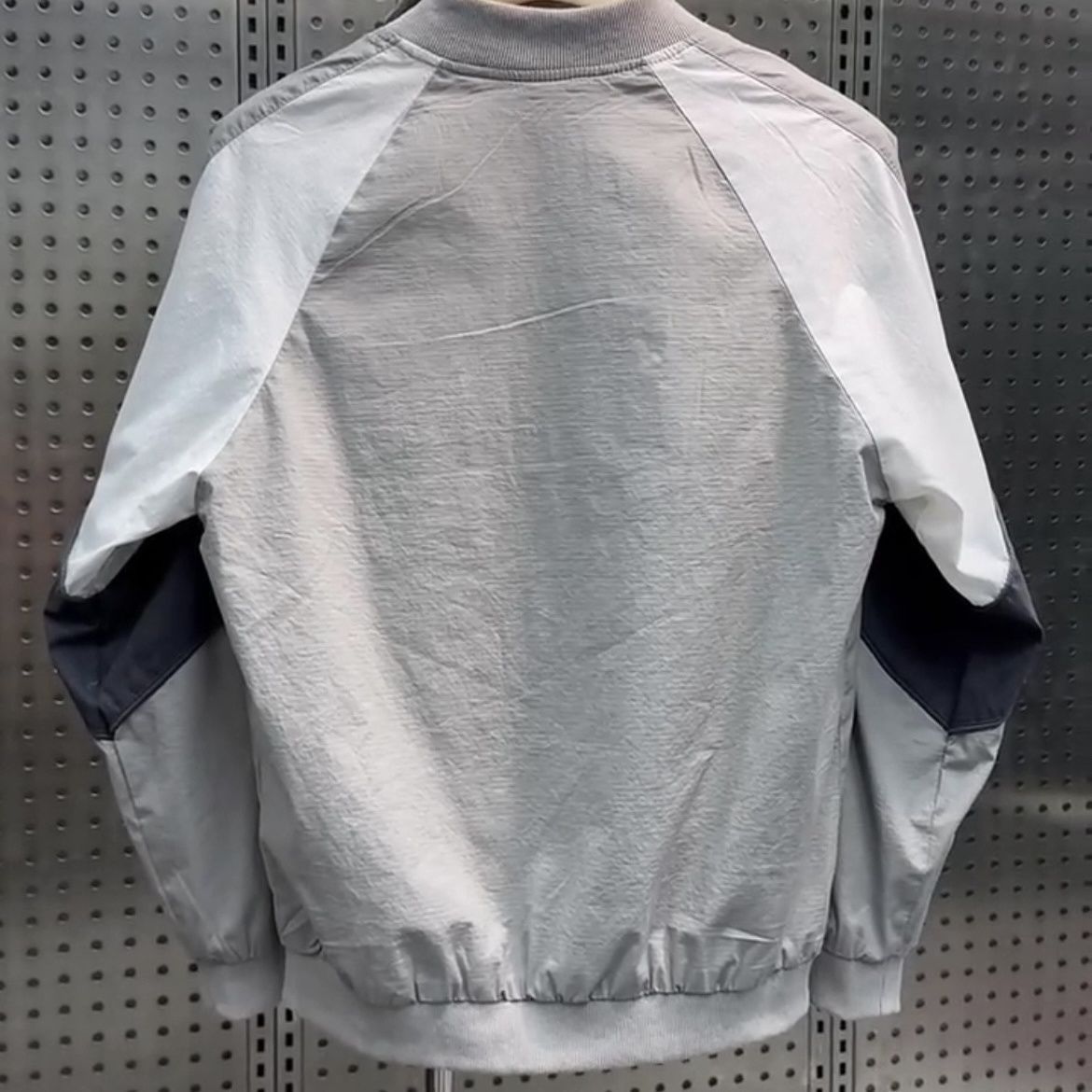 Thin baseball collar jacket styled with trousers as a light spring layer