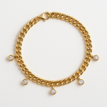 Cuban link bracelet on a wrist beside a watch in soft daylight