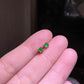 Green cabochon stud earring worn on a model ear lobe, small and close to the skin