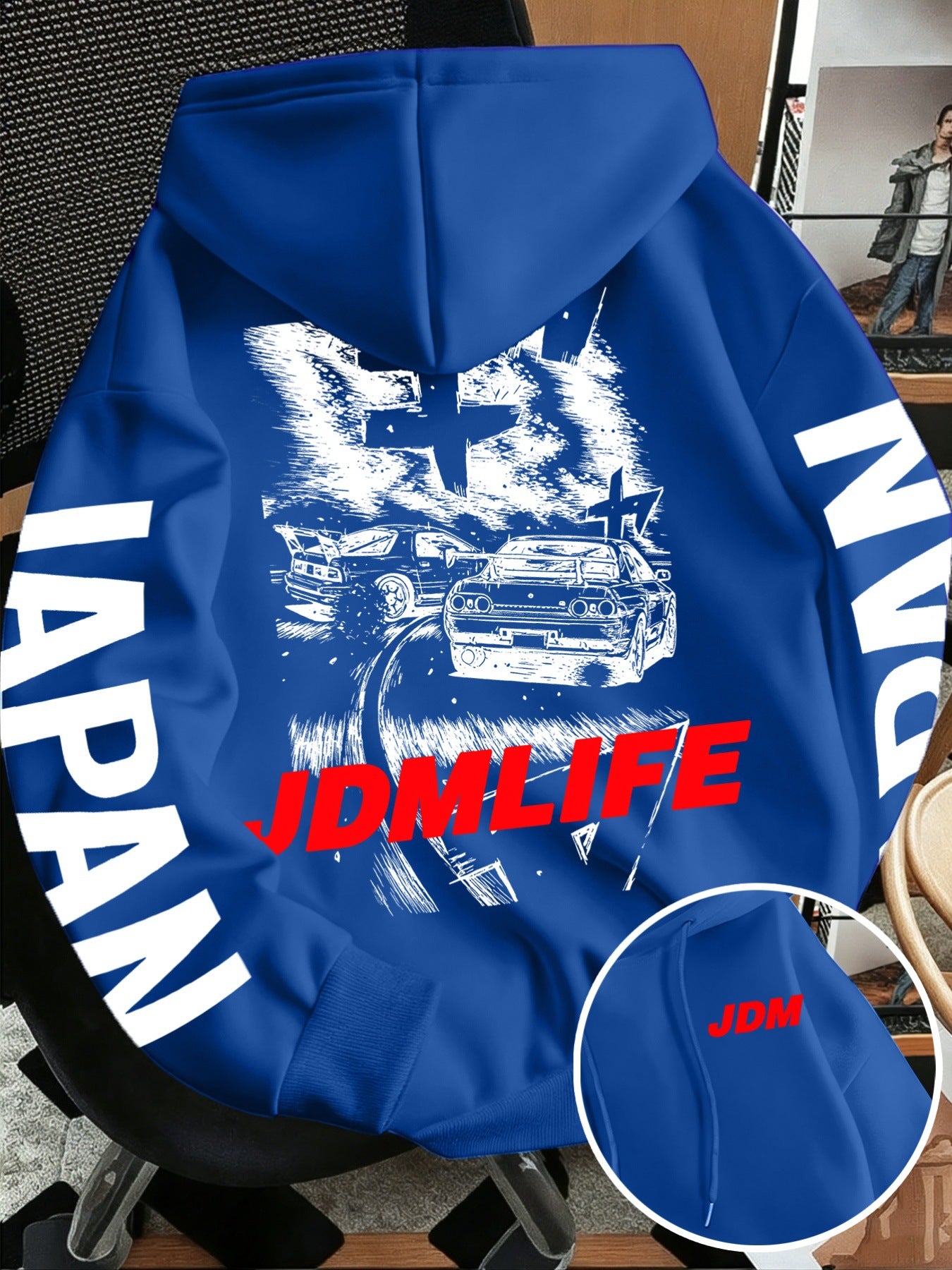 Front pocket detail of the JDM hoodie with a small red JDM tag beside the pouch pocket