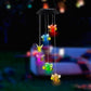 Bee LED figures glowing in several colors, hanging from a solar lamp head at night, black housing option