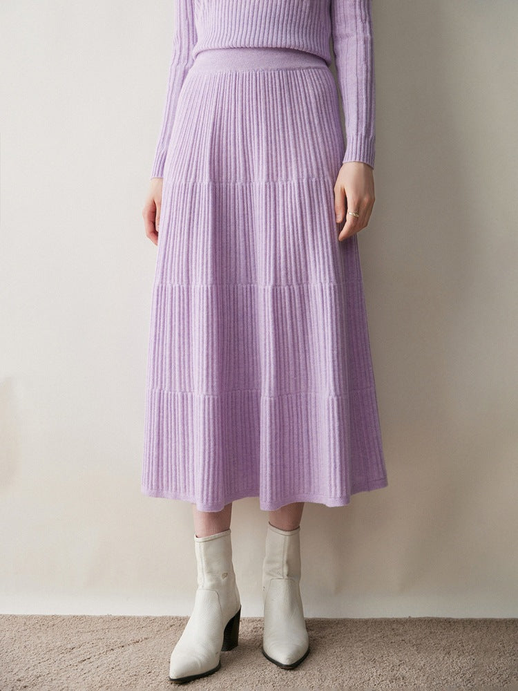 Woman wearing a lilac ribbed knit tiered midi skirt with cream ankle boots and a lilac knit top