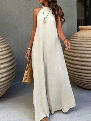 Apricot halter maxi dress styled with a gold starfish pendant and woven bamboo handbag, front view