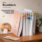 Row of open books upright on a shelf, each marked with a different colored silicone bookmark clip