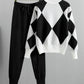 Black argyle knit sweater with white panels and matching black drawstring jogger pants on hangers against a white background
