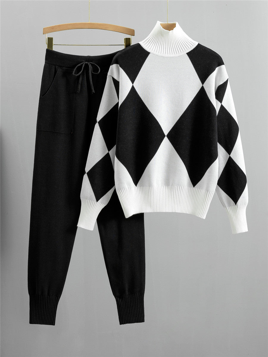 Black argyle knit sweater with white panels and matching black drawstring jogger pants on hangers against a white background