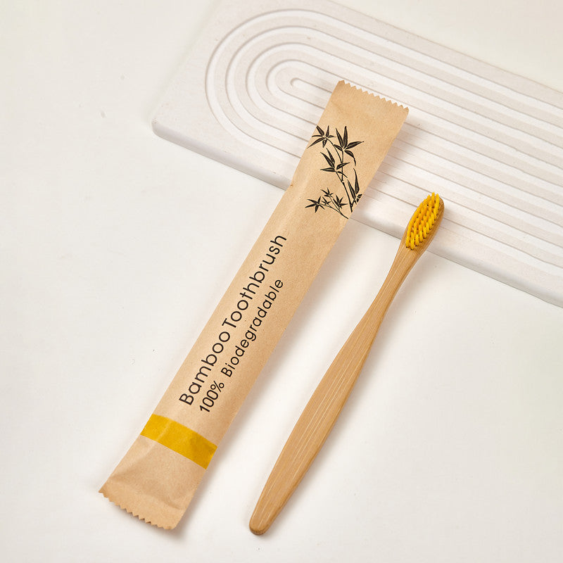 Bamboo toothbrush and kraft paper sleeve shown together on a light backdrop