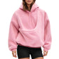 Woman wearing a pink plush fleece hoodie with a pouch pocket and black shorts, front view