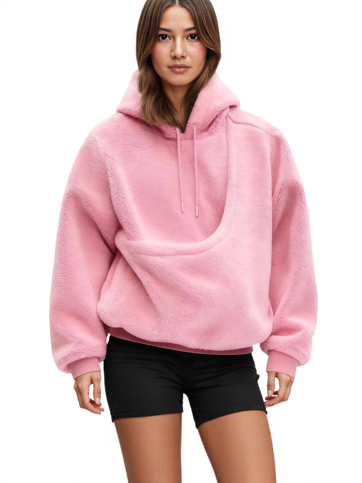 Woman wearing a pink plush fleece hoodie with a pouch pocket and black shorts, front view