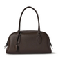 Hand holding the leather shoulder handbag for scale reference