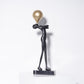 Detail of the polished black marble base and lower legs of the tall matte black figure sculpture