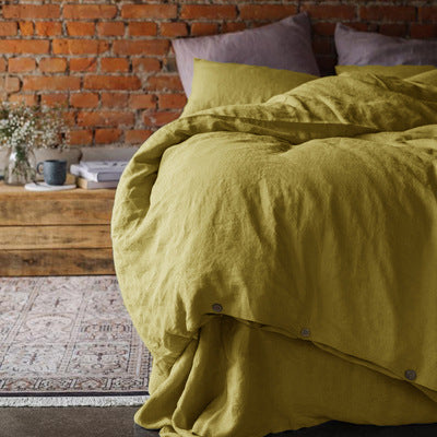 Washed cotton and linen blend bedding set in a soft solid color, styled on a made bed
