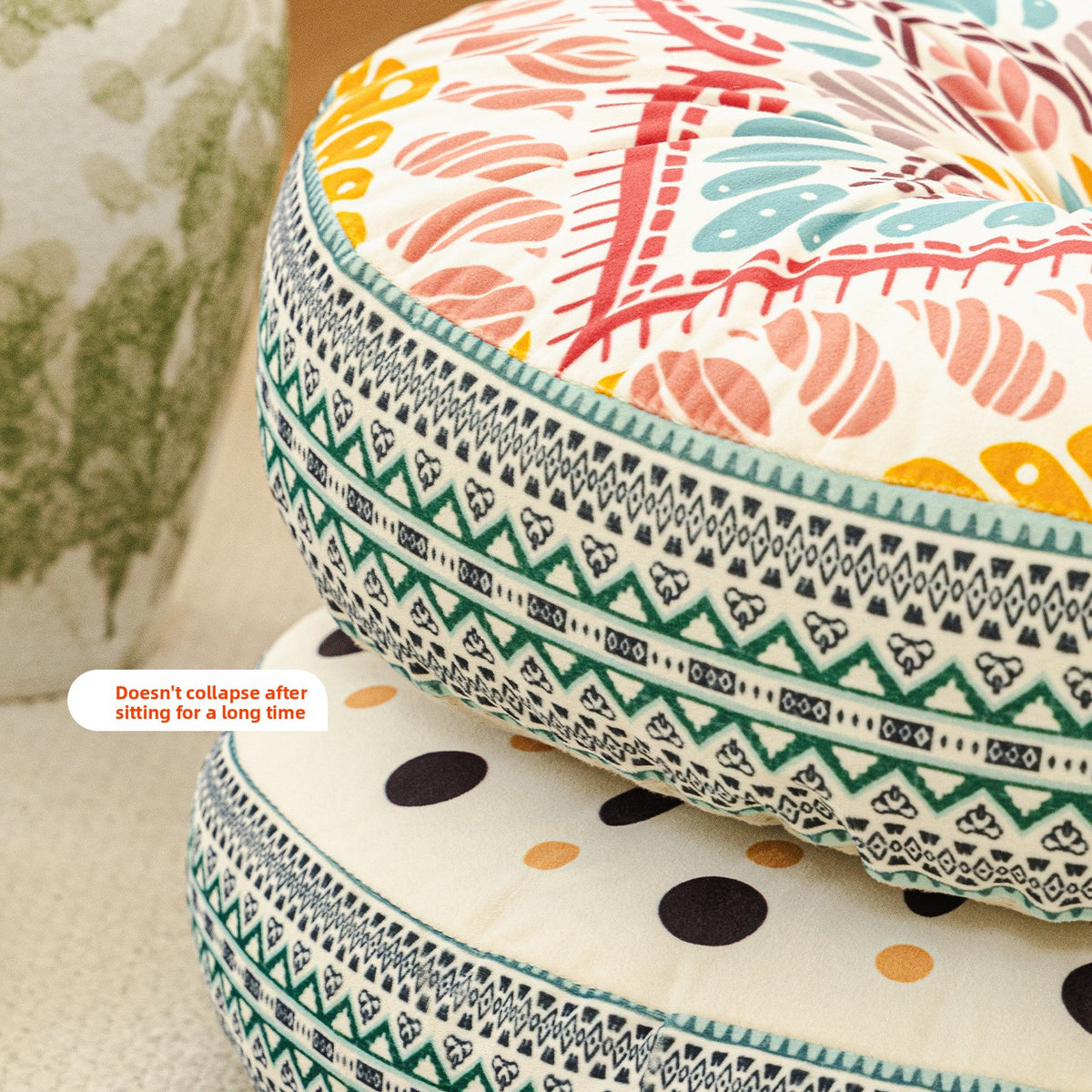 Close up of the side of stacked round print cushions showing a woven zigzag border and a polka dot design