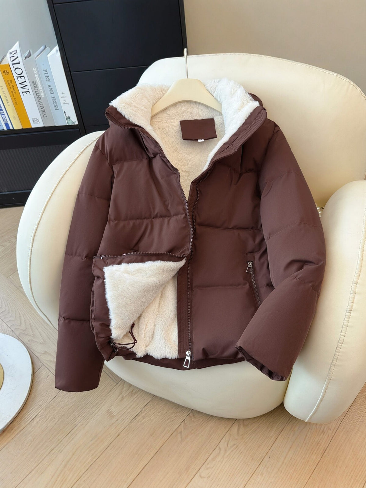 Close view of a zippered front pocket on the quilted hooded puffer jacket