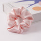 Satin hair scrunchie shown next to a gift box