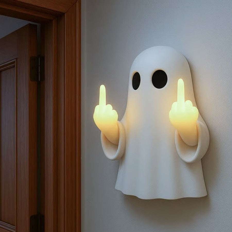 White resin ghost wall night light with two raised glowing hands mounted by a wooden doorway