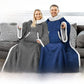Couple on a sofa in gray and navy sleeved blankets with sherpa collars and kangaroo pockets
