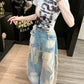 Light blue distressed wide leg baggy jeans with frayed star patches, full length view on a woman