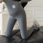 Dark gray option photo of dark gray maternity leggings with belly panel and label, woman kneeling on a sofa, size XXL