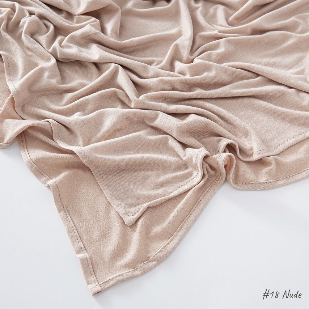 Solid tone modal cotton headscarf wrap laid in soft folds showing the fine jersey knit surface