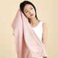 Woman holding a large pink coral fleece towel against her hair, front view
