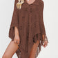 Openwork knit fringe poncho falling open over the arms with a collared tie neckline