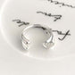 Close up scale reference of the slim open silver ring band and accent