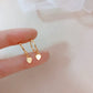 Heart ear cuff stacked with a small gold hoop in the lobe