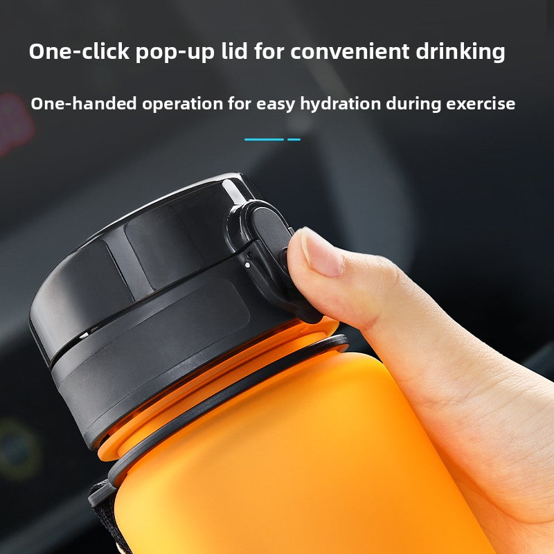 Close view of a thumb pressing the button on the black flip lid of an orange bottle