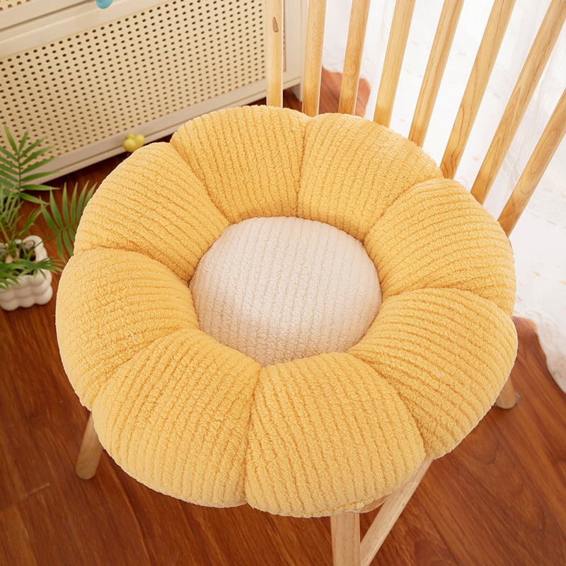 Flower shaped plush seat cushion placed on a floor as a soft place to sit