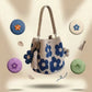 Blue floral crochet cotton bucket bag with a tassel charm and yarn balls on a soft background