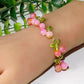 Lapis lazuli blue bead clusters with green leaves along a gold tone chain bracelet