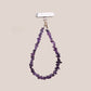 Purple bead phone strap clipped to a phone and carried at the wrist