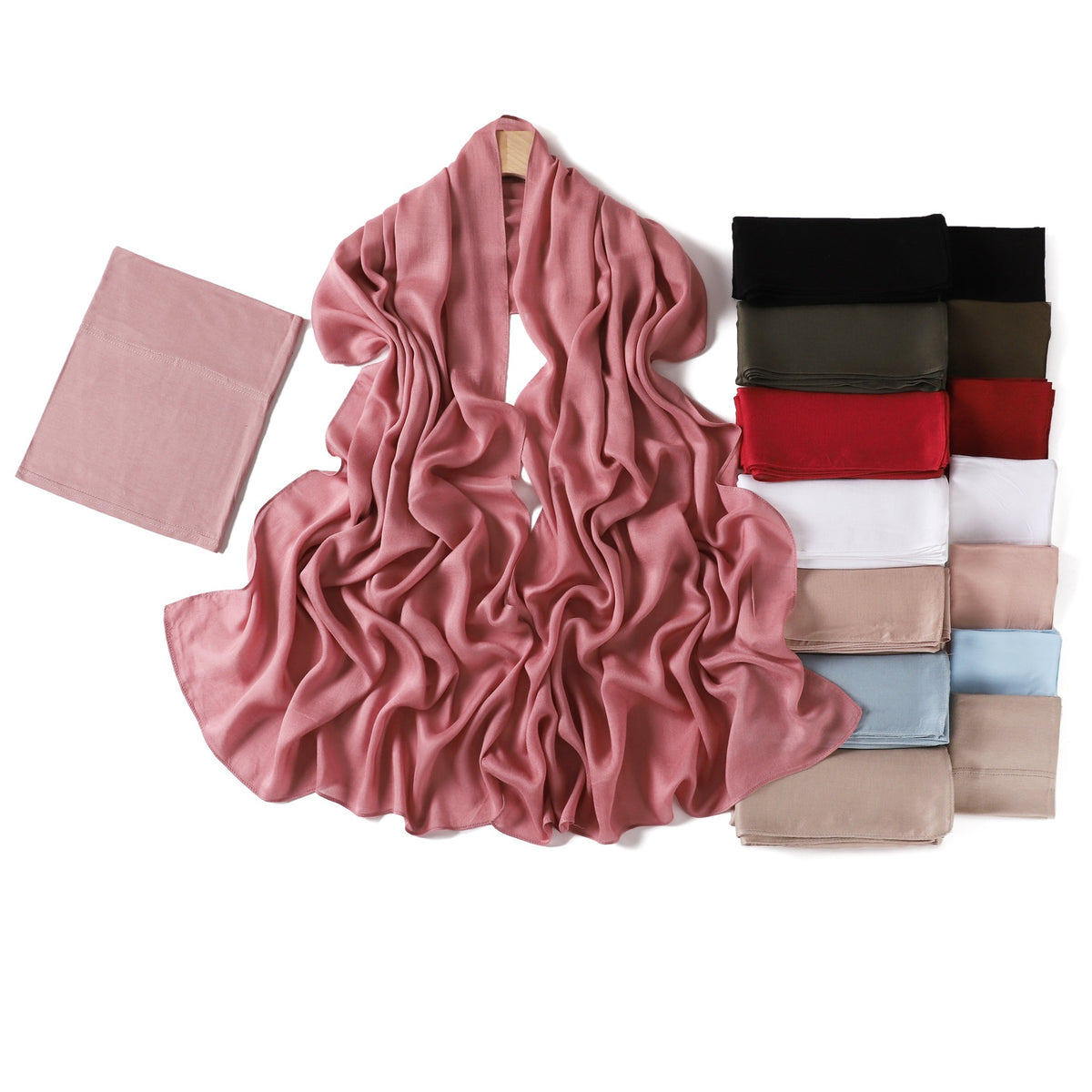 Folded jersey undercap beside a rose modal rayon hijab scarf on a wooden hanger with a color stack