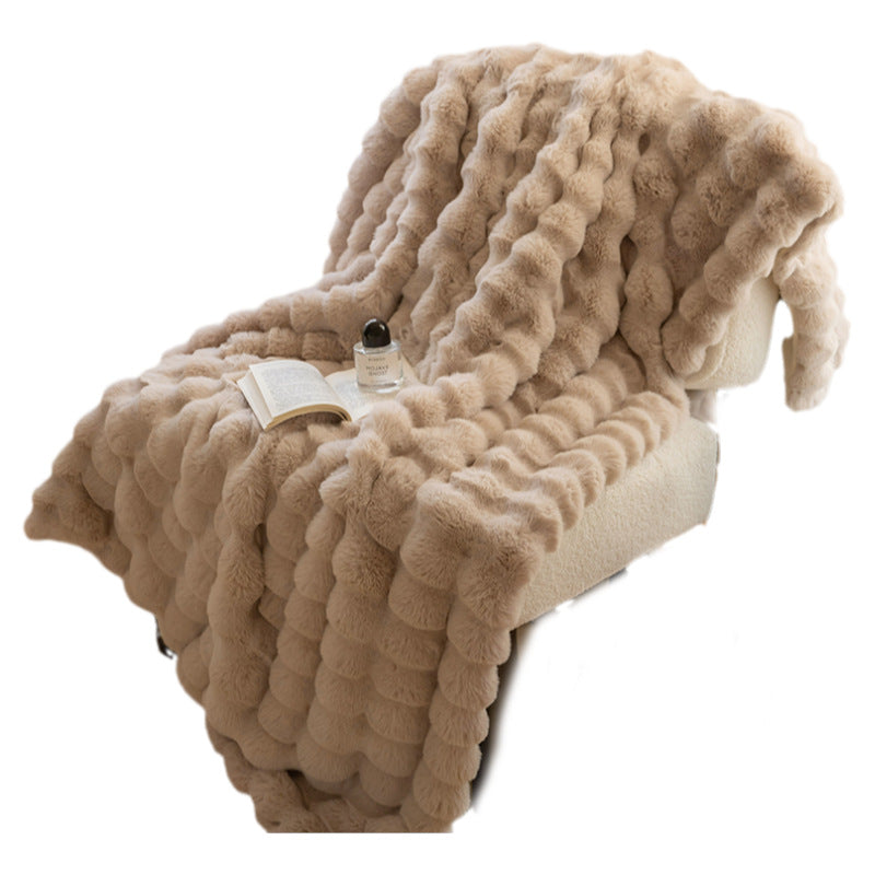 Corner of a ruched plush throw blanket showing the rows of soft fabric bubbles