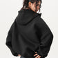 Back view of the oversized hooded sweatshirt showing the deep hood and ribbed hem
