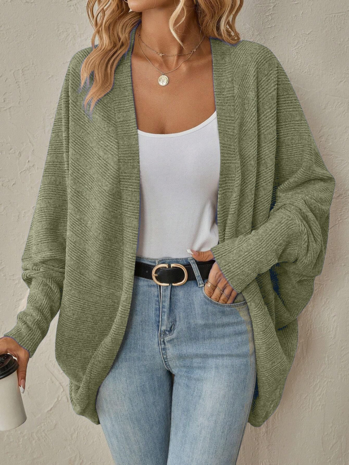 Front view of a light gray womens knit cardigan worn open over a cami