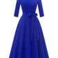 Vintage swing dress on a hanger showing the back zip and pleated skirt drop