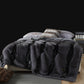Dark Gray with Black Stripes option: dark gray vegan fur blanket with black diagonal stripes on a bed