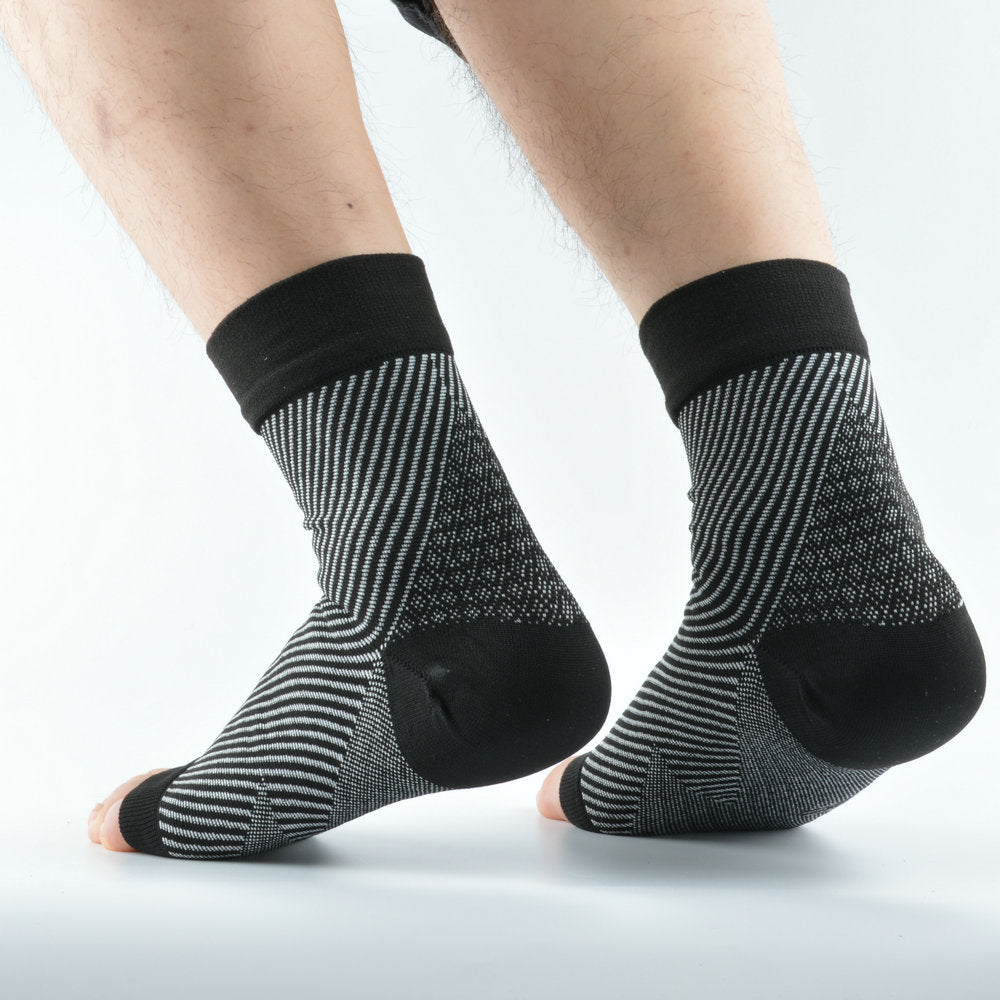 Copper and black knit compression foot sleeves on both feet, rear view, mesh vented arch panel visible