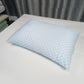 Rectangular memory foam bed pillow with a quilted cooling knit cover resting on white sheets