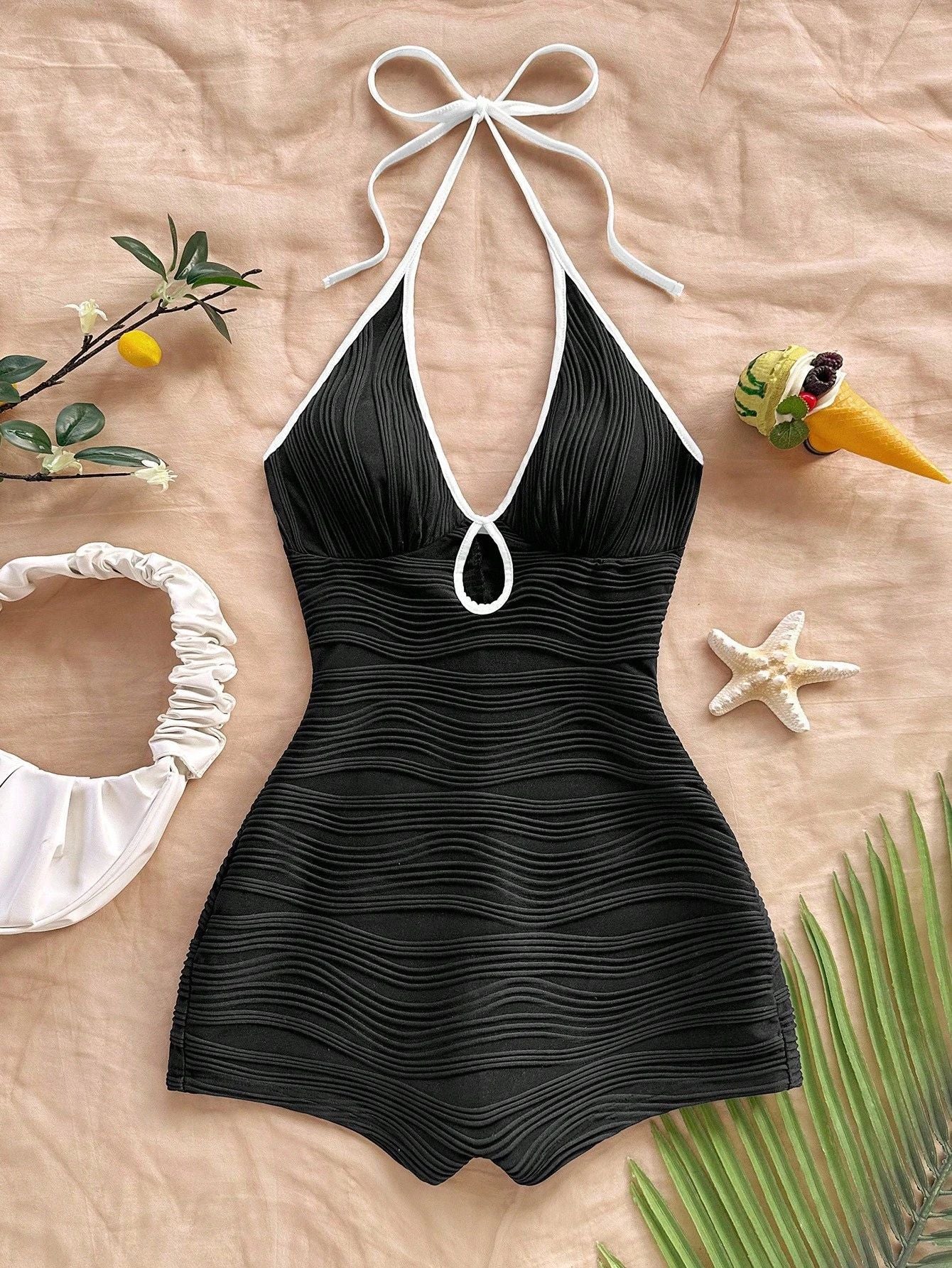 Halter neck bodycon romper in white rippled stretch fabric with a self tie bow and keyhole cutout
