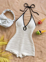 Halter neck bodycon romper in white rippled stretch fabric with a self tie bow and keyhole cutout