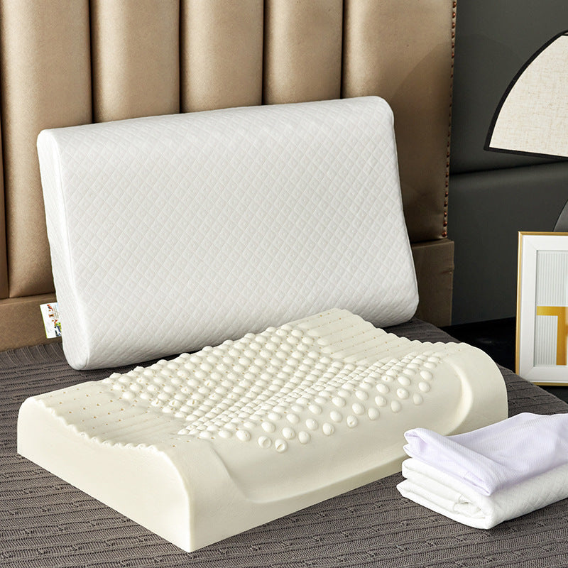 White covered contour pillow beside a cream latex core with a raised nub massage surface