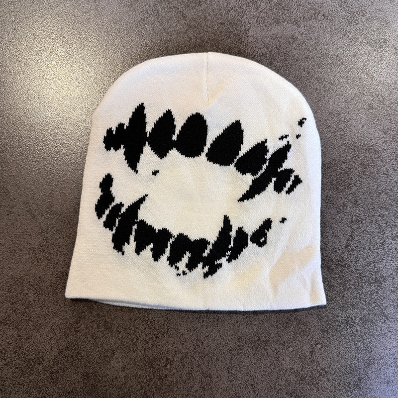 Ghost pattern knit winter beanie in white shown on a plain surface